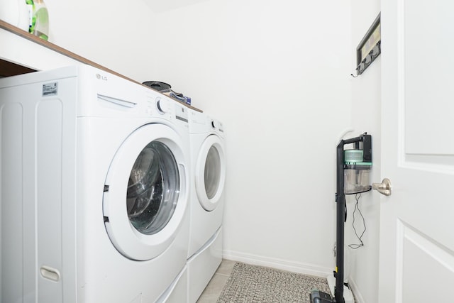 laundry area featuring washing machine and dryer and light tile patterned floors