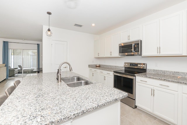 kitchen featuring light stone countertops, white cabinetry, appliances with stainless steel finishes, and sink