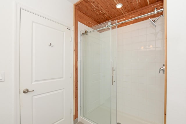 bathroom featuring wooden ceiling and a shower with shower door