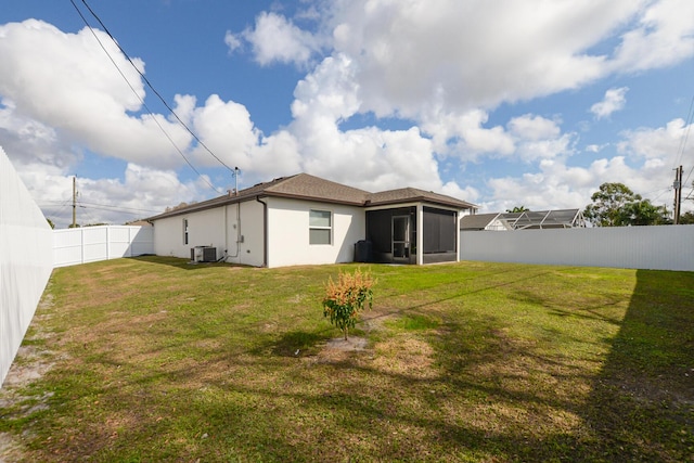 back of house featuring cooling unit, a lawn, and a sunroom