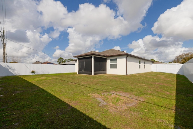 back of house featuring a yard and a sunroom