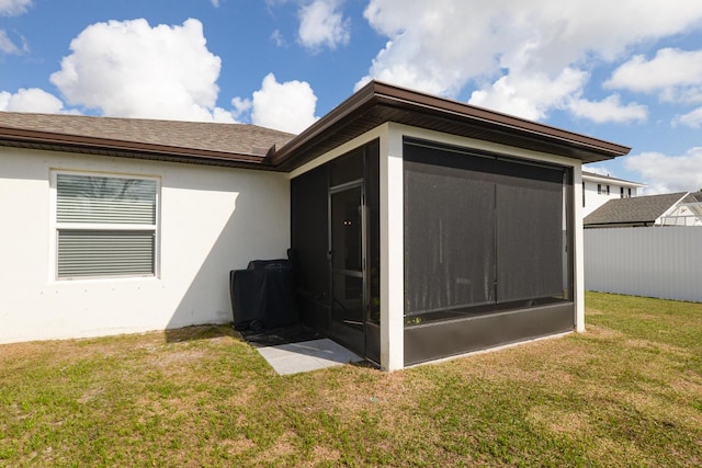 view of side of property with a yard and a sunroom