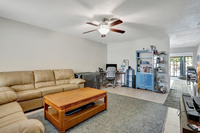 tiled living room featuring ceiling fan and a textured ceiling