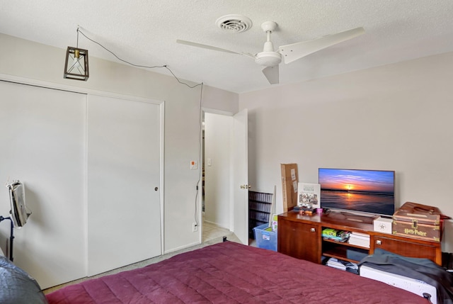 bedroom featuring ceiling fan, a closet, and a textured ceiling