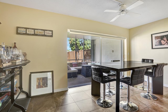 dining room featuring tile patterned flooring, ceiling fan, and a textured ceiling