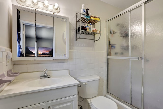 bathroom featuring vanity, tile walls, an enclosed shower, and toilet