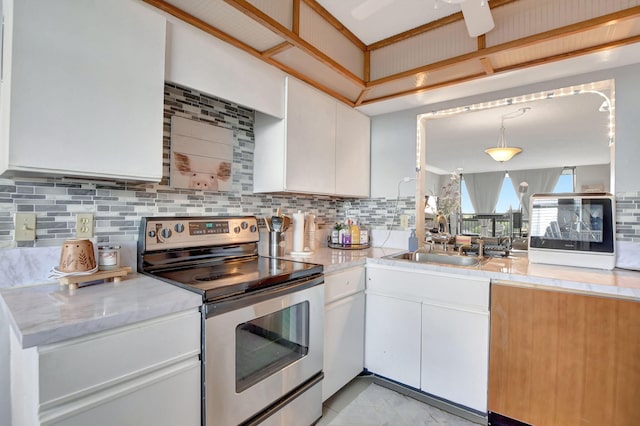 kitchen with tasteful backsplash, white cabinets, stainless steel electric stove, and pendant lighting