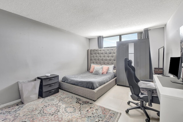 bedroom with a textured ceiling and light tile patterned flooring