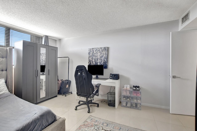 bedroom featuring a textured ceiling and light tile patterned floors