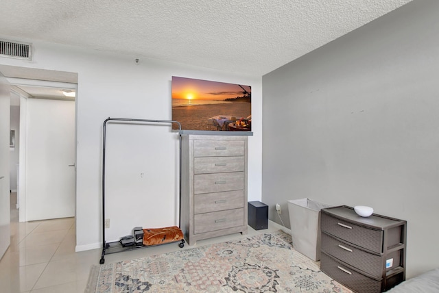 bedroom featuring a textured ceiling and light tile patterned floors