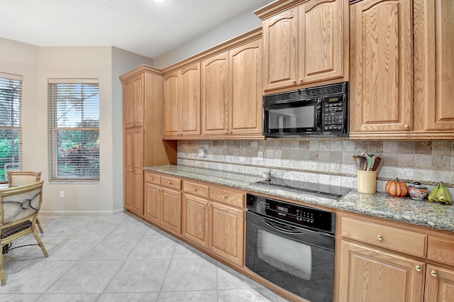 kitchen featuring black appliances, backsplash, light tile patterned floors, and light stone countertops