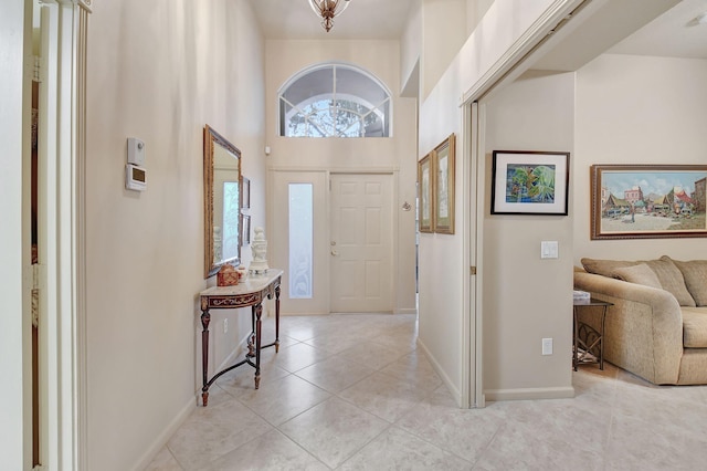 foyer with light tile patterned floors and a towering ceiling