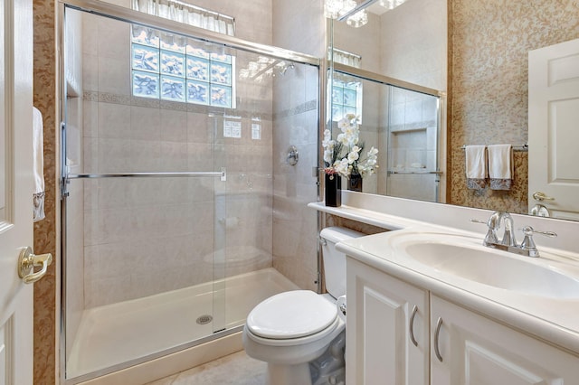 bathroom featuring toilet, tile patterned flooring, an enclosed shower, and vanity