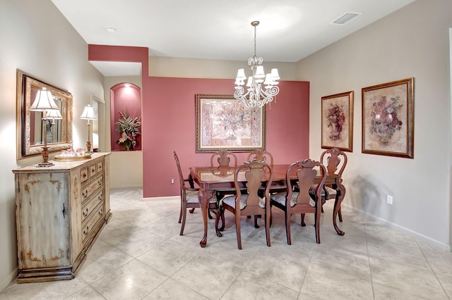 tiled dining space with a chandelier