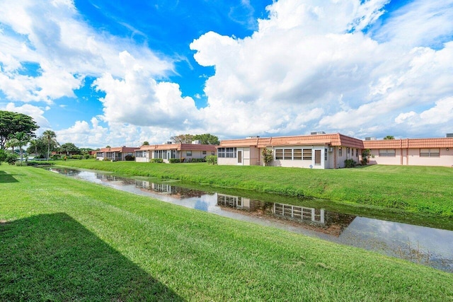 view of home's community with a water view and a yard