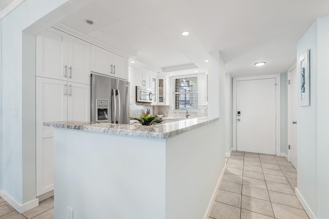 kitchen with kitchen peninsula, white cabinetry, and appliances with stainless steel finishes