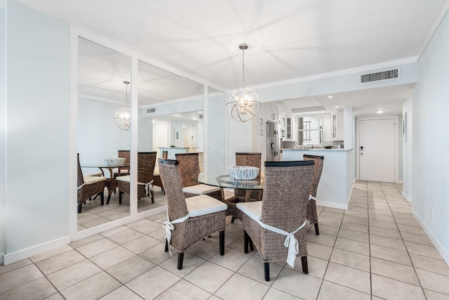 tiled dining space featuring ornamental molding and an inviting chandelier