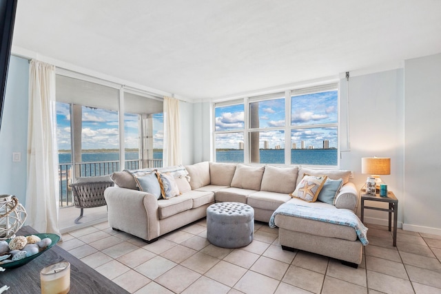 tiled living room featuring a water view and expansive windows