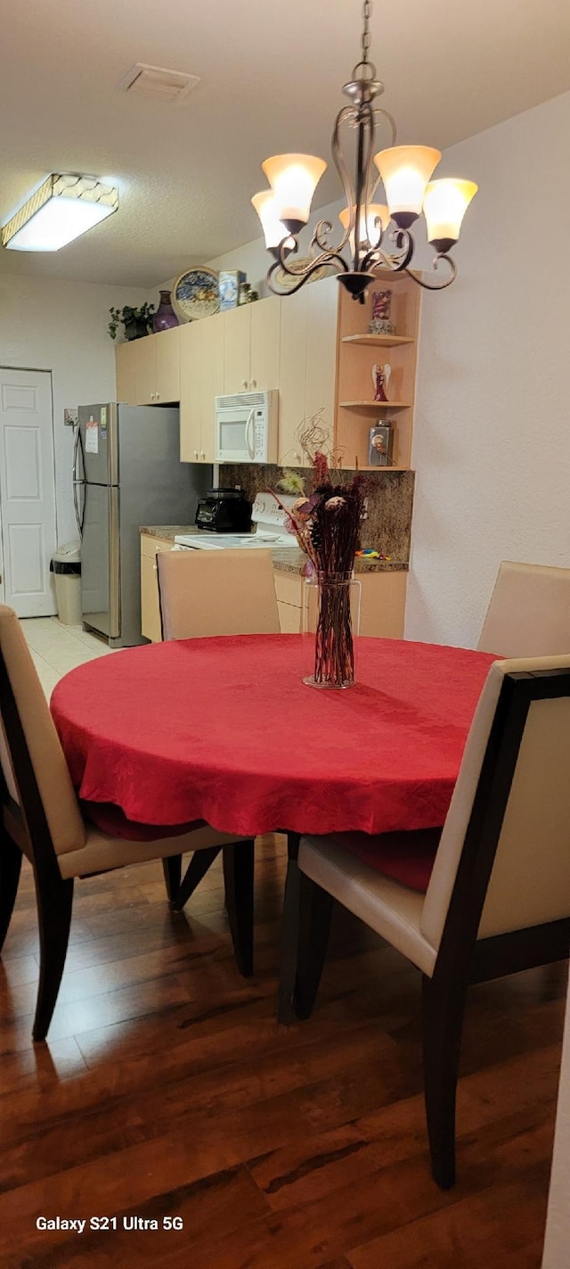 dining area featuring hardwood / wood-style flooring and a chandelier