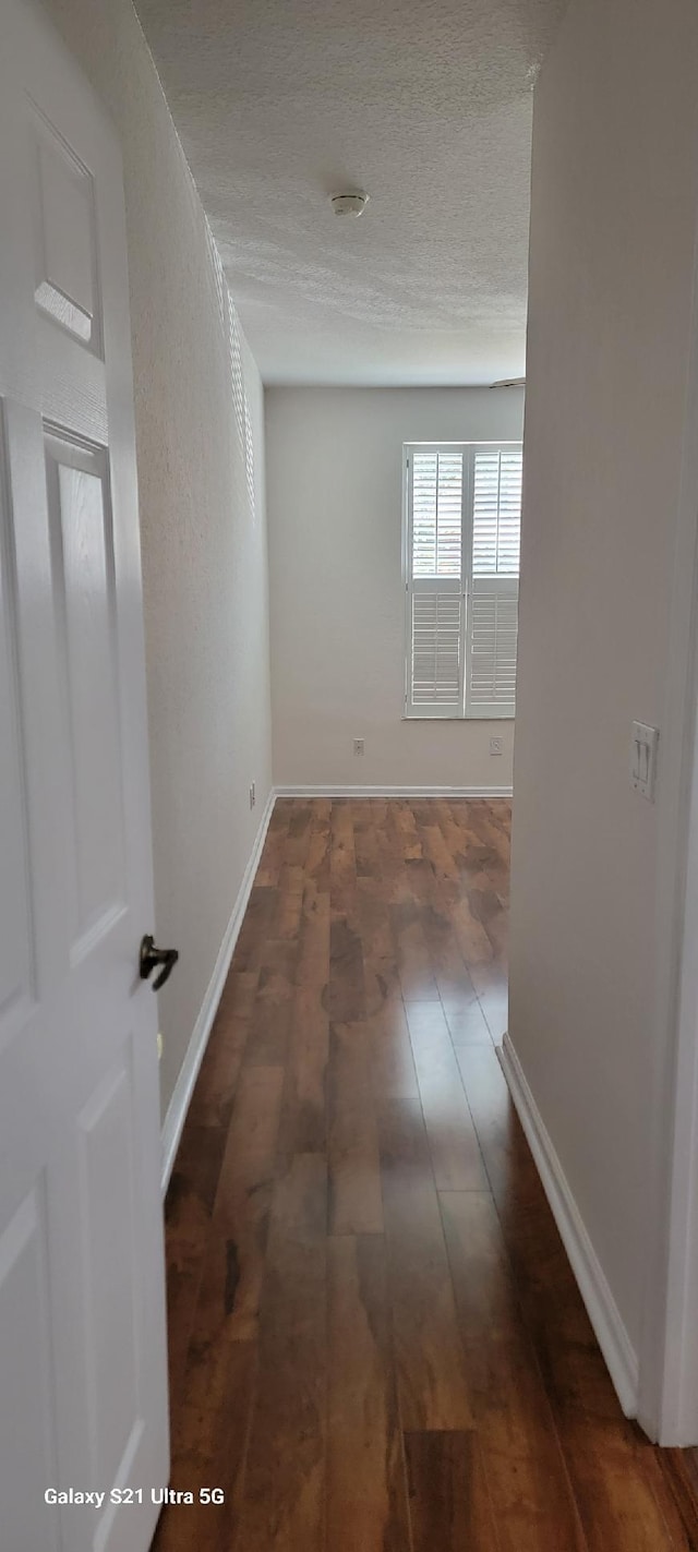 3569 Forest Hill Blvd Unit 103, Palm Springs, FL 33406 - corridor with a textured ceiling, baseboards, and wood-type flooring