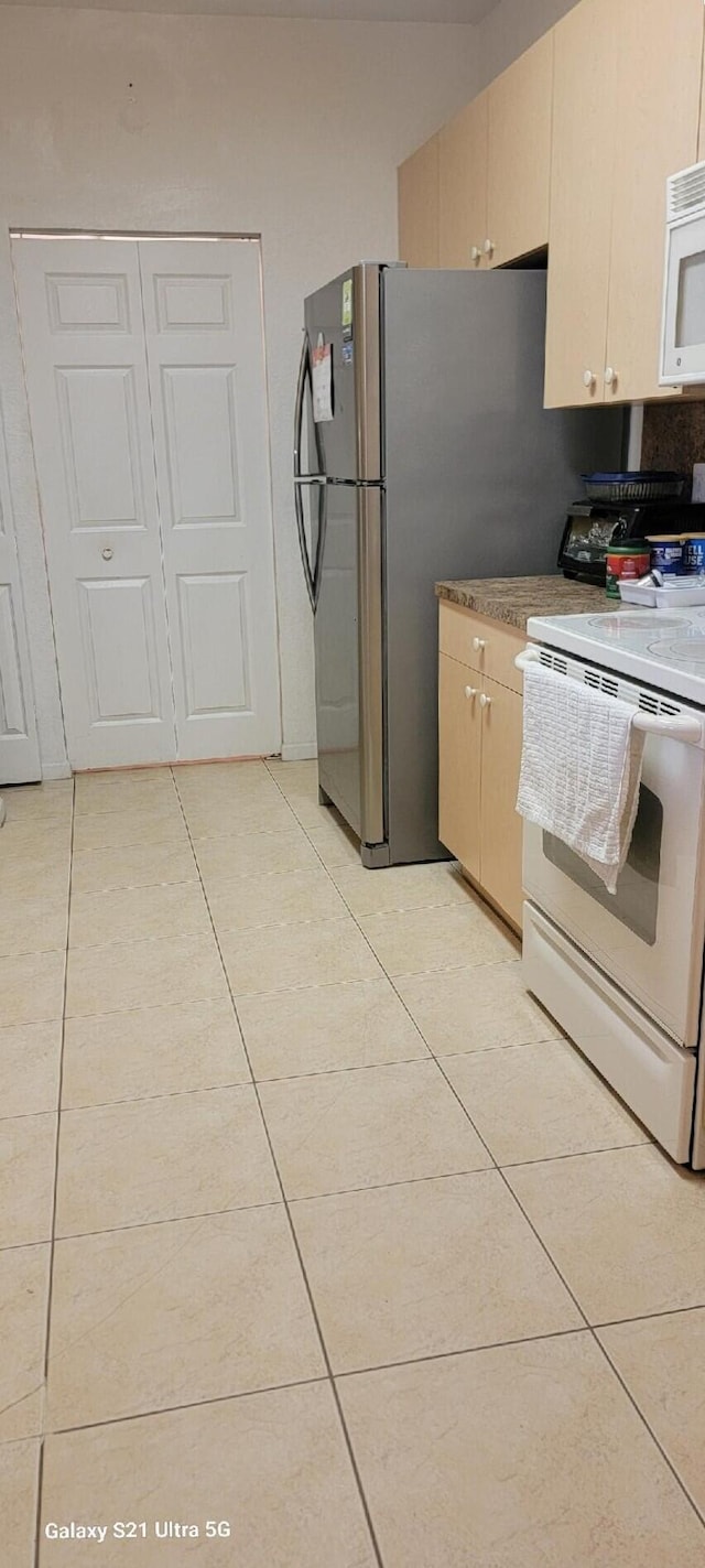 kitchen with light tile patterned floors and white appliances