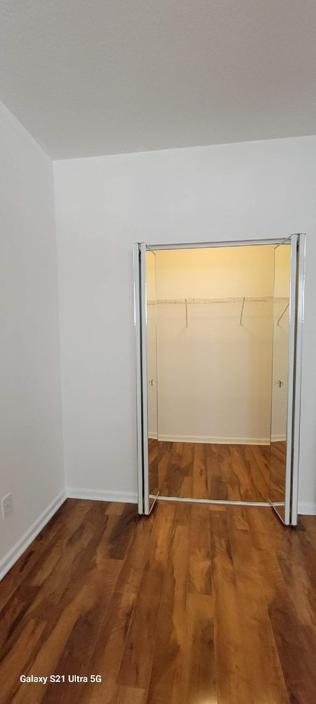 3569 Forest Hill Blvd Unit 103, Palm Springs, FL 33406 - unfurnished bedroom featuring wood finished floors, baseboards, and a closet