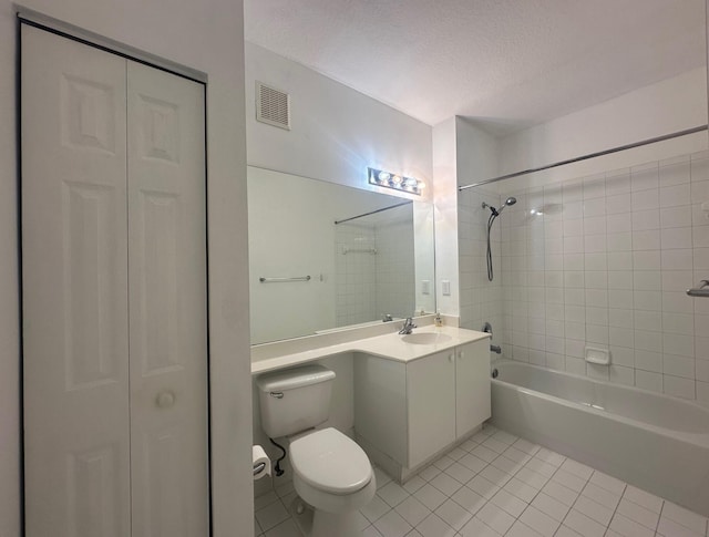 full bathroom featuring tiled shower / bath combo, vanity, a textured ceiling, tile patterned floors, and toilet