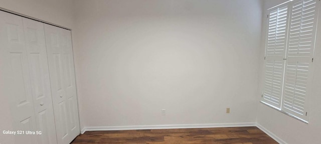 3569 Forest Hill Blvd Unit 103, Palm Springs, FL 33406 - unfurnished bedroom with a closet, dark wood-style flooring, and baseboards
