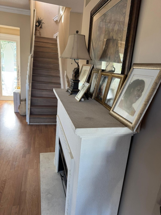 stairway featuring ornamental molding and wood-type flooring