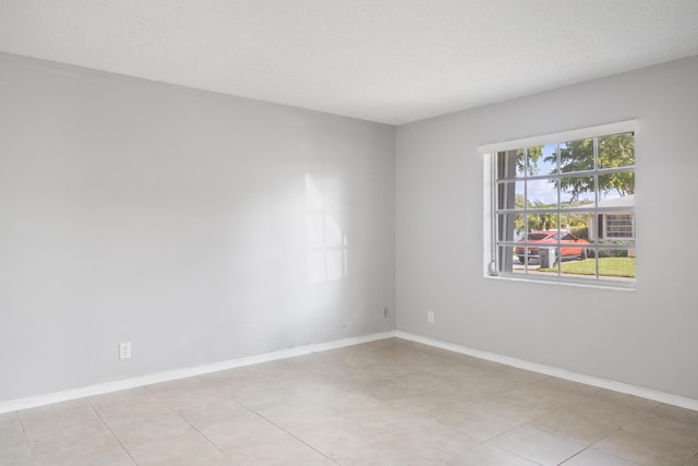 tiled spare room featuring a textured ceiling