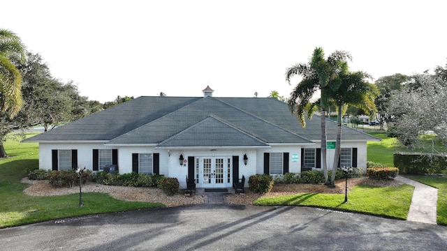 view of front of property with french doors and a front lawn