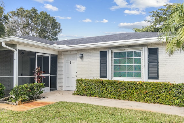 view of exterior entry with a yard