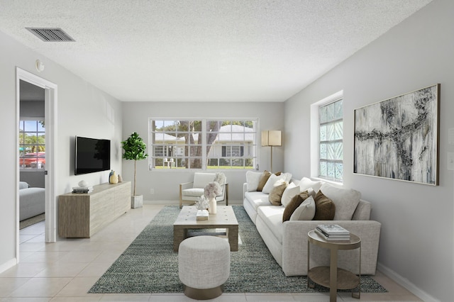 living room with light tile patterned flooring and a textured ceiling