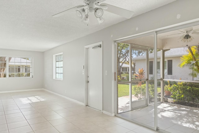 entryway featuring ceiling fan, a textured ceiling, and light tile patterned flooring