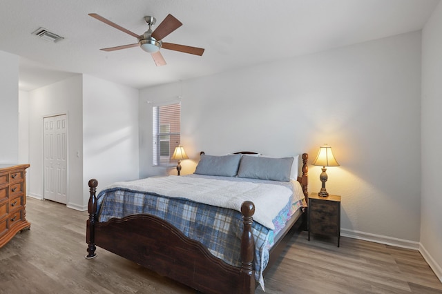 bedroom featuring ceiling fan, hardwood / wood-style floors, and a closet