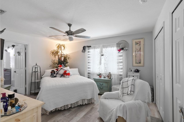 bedroom featuring ceiling fan, a textured ceiling, and light wood-type flooring