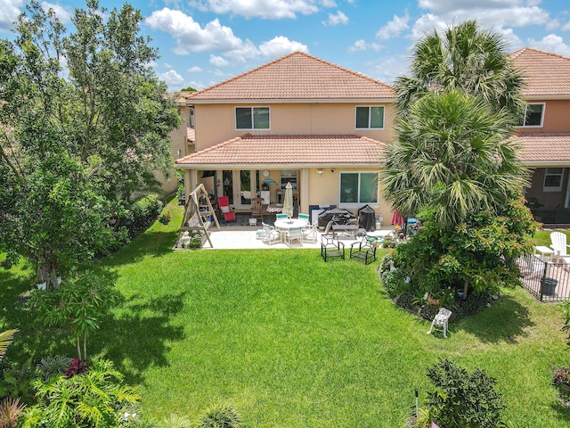 back of house with a yard and a patio area