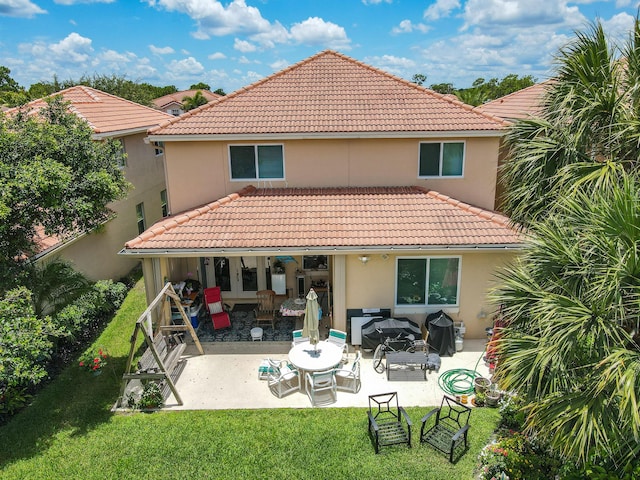 back of house featuring a patio area and a lawn