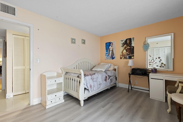 bedroom with hardwood / wood-style flooring and a textured ceiling