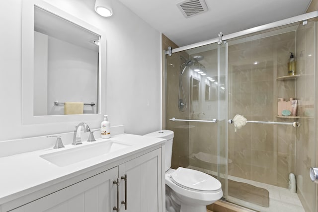 bathroom featuring vanity, toilet, and walk in shower