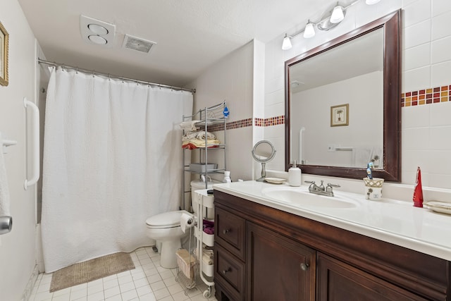 bathroom with vanity, tile patterned flooring, and toilet