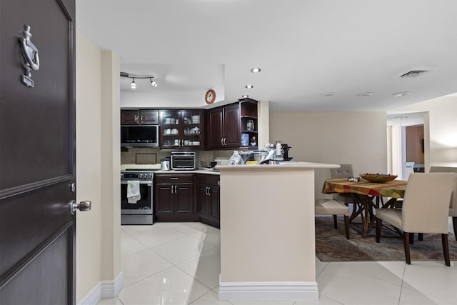 kitchen featuring appliances with stainless steel finishes, dark brown cabinets, and light tile patterned floors