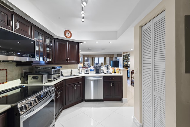 kitchen featuring dark brown cabinetry, stainless steel appliances, sink, and light tile patterned floors