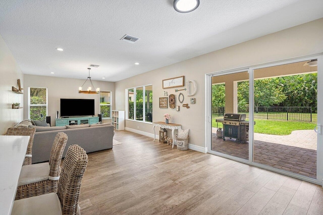 living room with a textured ceiling and light hardwood / wood-style floors