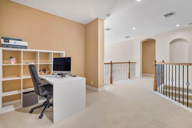 carpeted home office with a textured ceiling