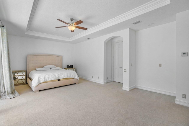 carpeted bedroom with ceiling fan, crown molding, a tray ceiling, and a textured ceiling