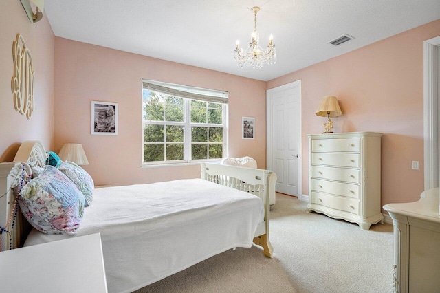 bedroom featuring light colored carpet and a notable chandelier