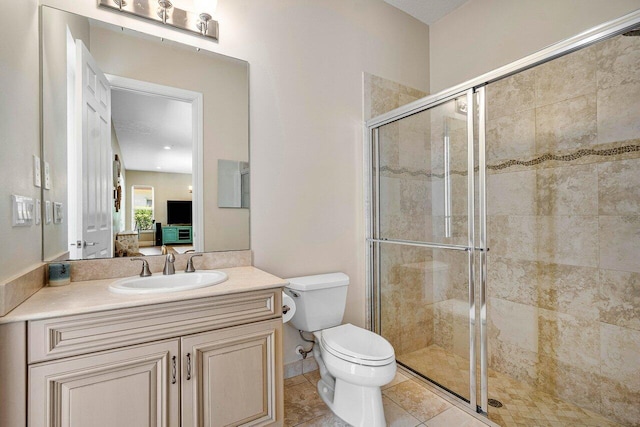 bathroom featuring toilet, tile patterned floors, a shower with door, and vanity