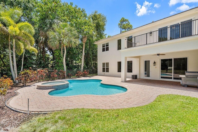 view of swimming pool with ceiling fan, a patio, and an in ground hot tub