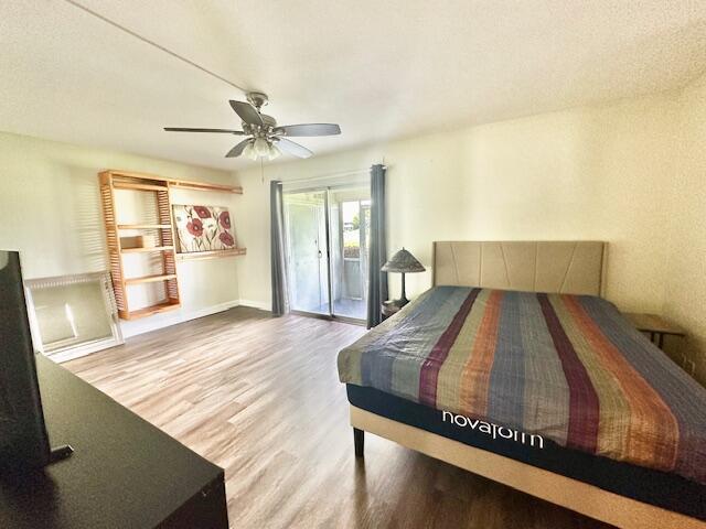 bedroom with ceiling fan, access to exterior, and wood-type flooring